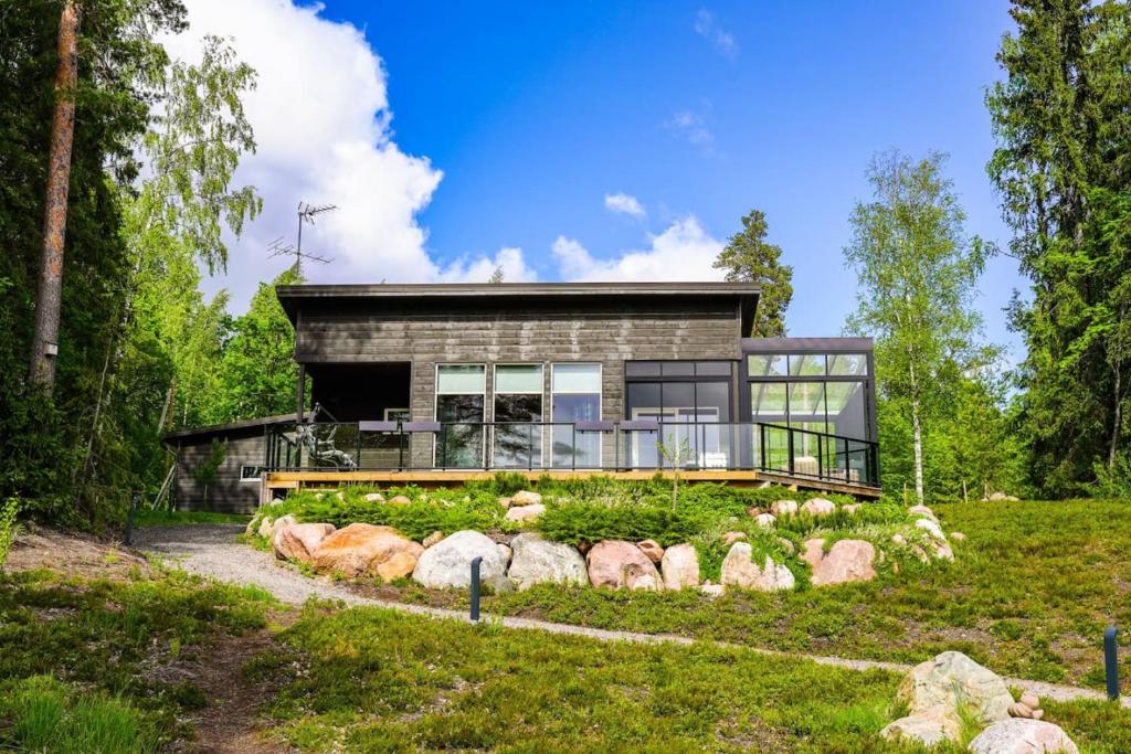 una casa en medio de un campo en Villa Ritva - Modern - Lakefront - Hot Tub en Hyvinkää