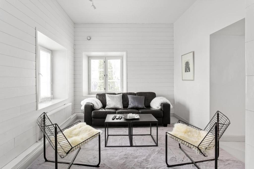 a living room with a couch and two chairs at Charming Riverside House with Terrace in Turku