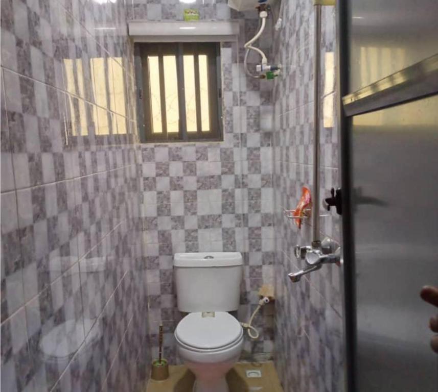 a small bathroom with a toilet and a window at Kings Lux Home in Lagos