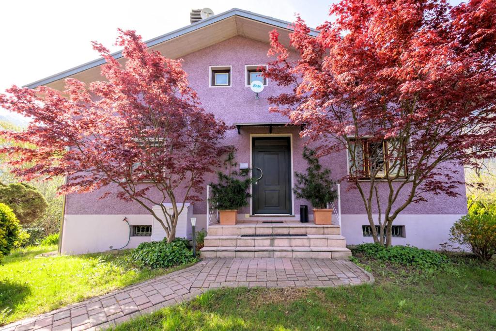 una casa púrpura con árboles delante de ella en REVO Apartments - Casa Viola, en Berbenno di Valtellina