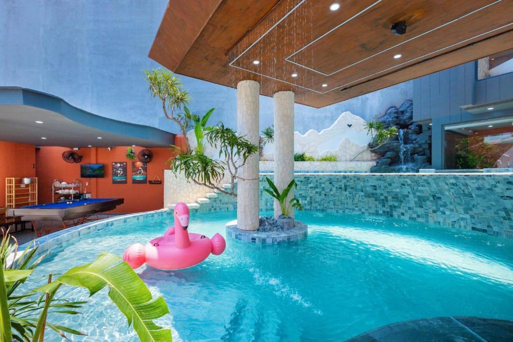 a swimming pool with a pink float in a house at Wabi Sabi Villa * Hồ Bơi Thác Nước 140 m2 * Phòng Karaoke Thủy Cung in Vung Tau