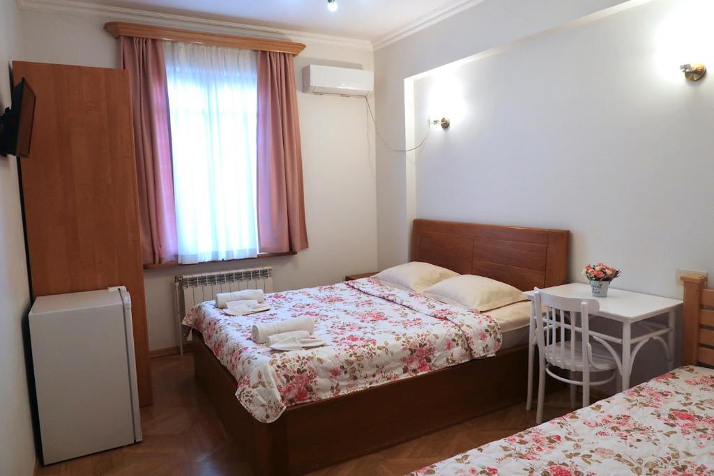 a small bedroom with two beds and a window at guest house Merci in Tbilisi City