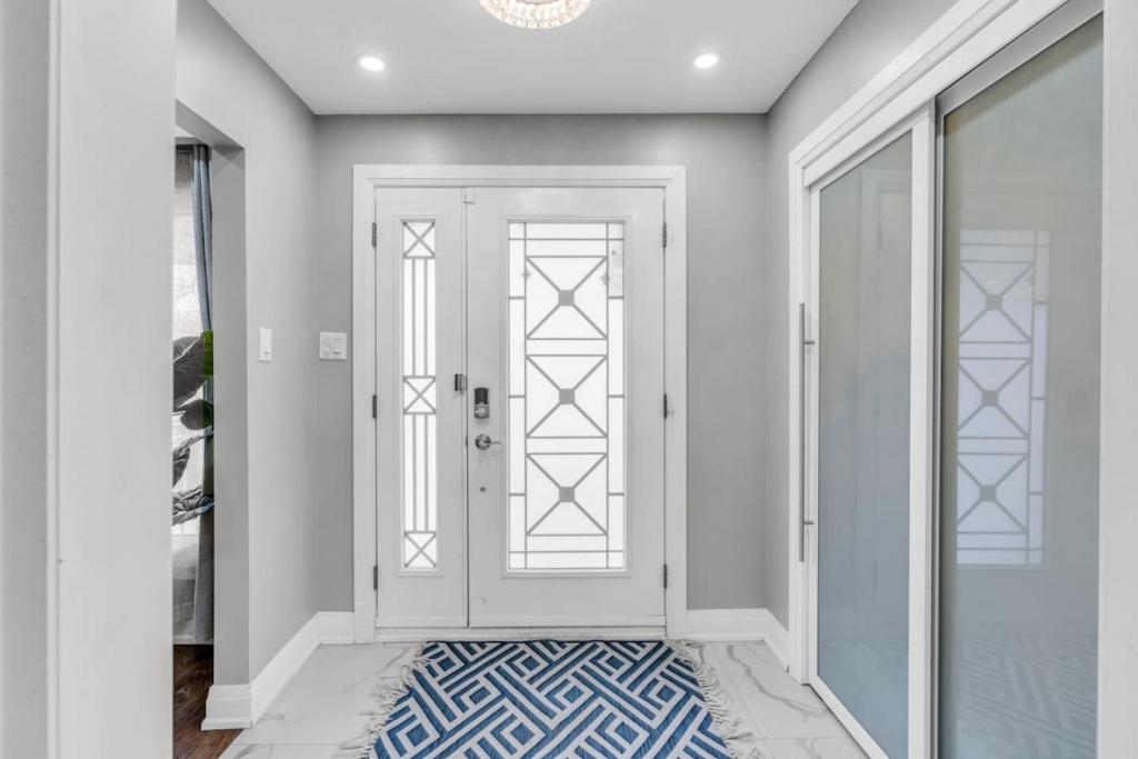 un pasillo con una puerta blanca y una alfombra azul en Golfers Heaven I Luxury Home in GTA I Central Area, en Mississauga