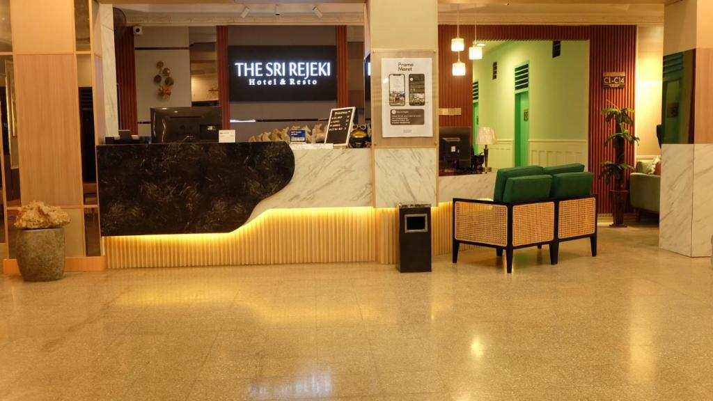 eine Lobby mit einer Theke und Stühlen in einem Gebäude in der Unterkunft The Sri Rejeki Hotel in Blitar