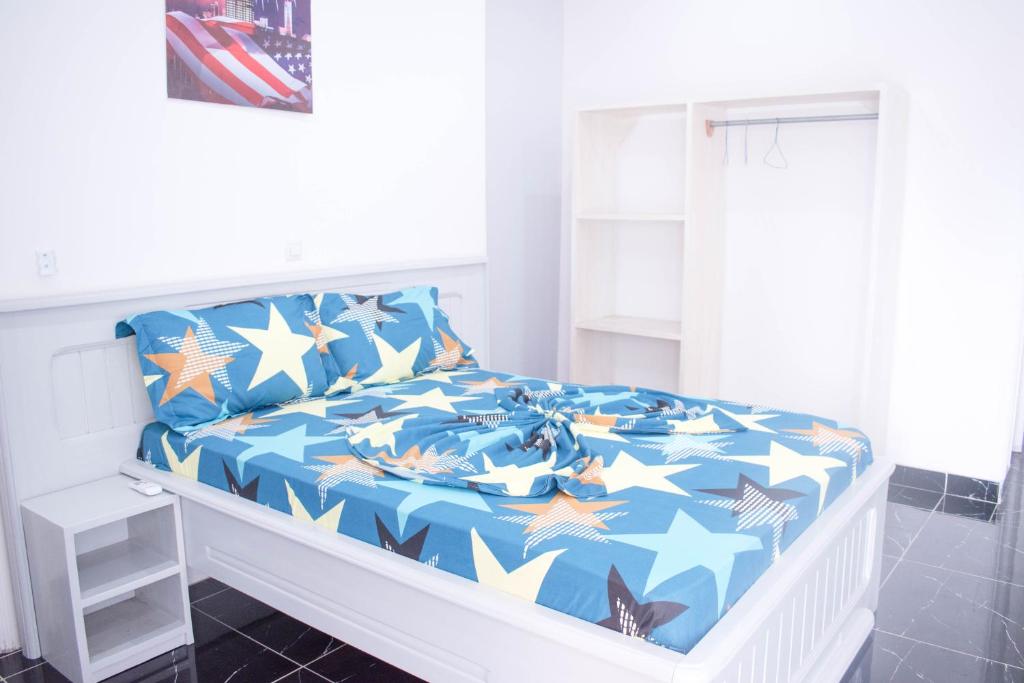 Una cama con un edredón azul con estrellas. en Studio moderne avec Balcon en Pointe-Noire