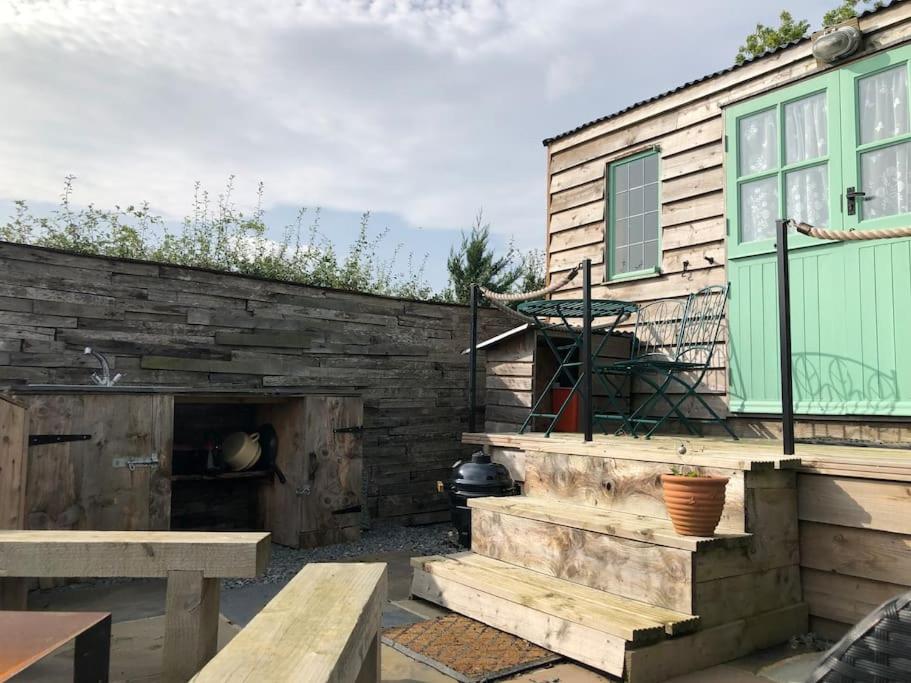 a patio with a bench and a building at Shepherd’s Hut with complete privacy in Bottesford