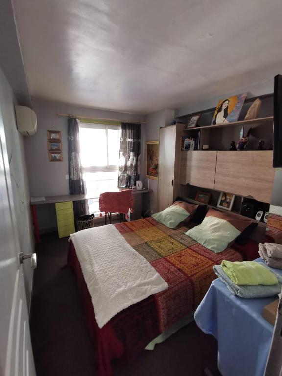 une chambre avec un lit, une table et une fenêtre dans l'établissement Agréable chambre d'hôte à 50M de la mer, à Cannes
