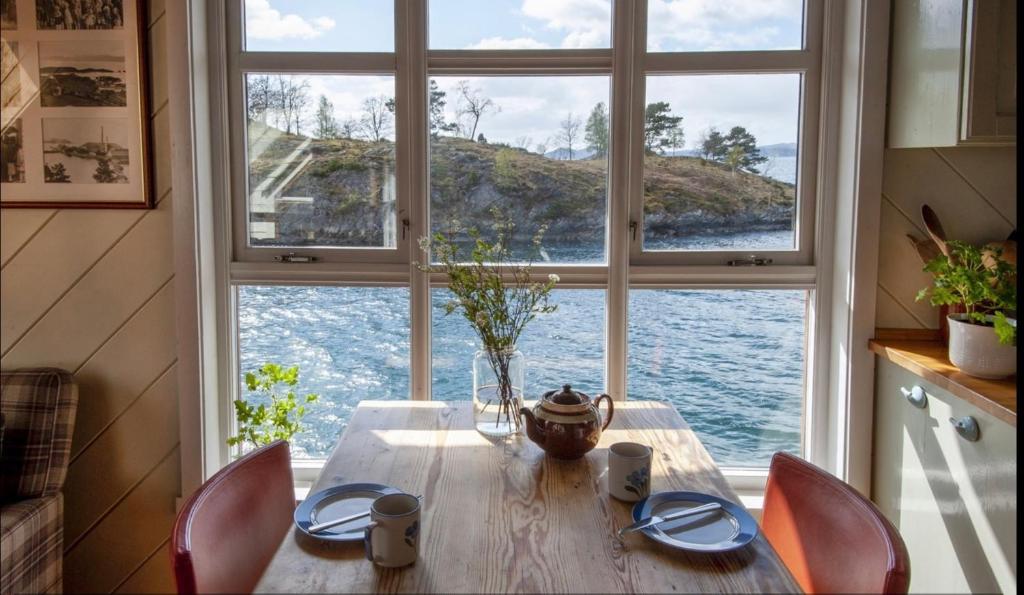 a dining room table with a view of the water at Salteriet in Vinnes