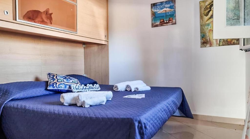 a bedroom with a blue bed with towels on it at Case Vacanze Gnocchi in Trappeto