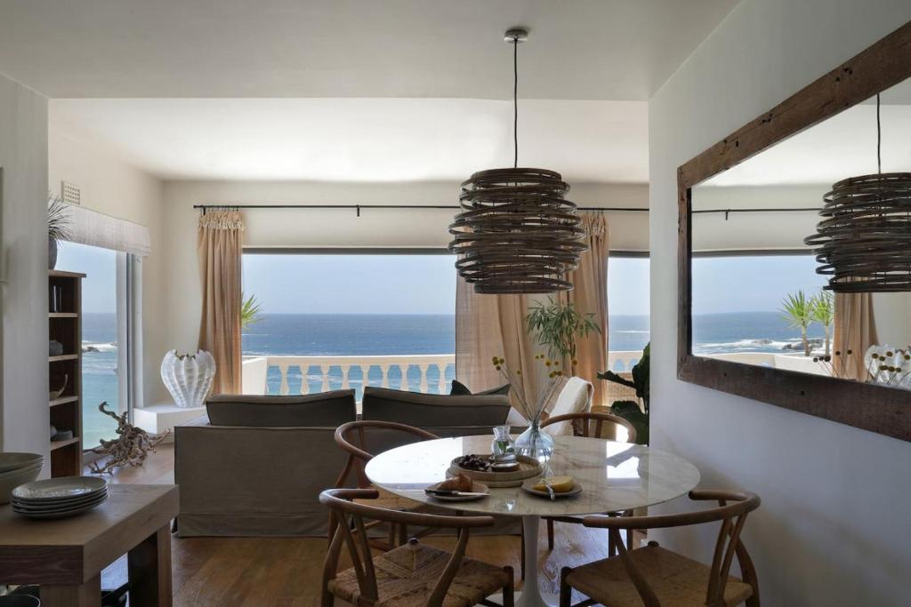 a living room with a table and a view of the ocean at Scenic Serenity in Clifton - Number 6306 in Cape Town
