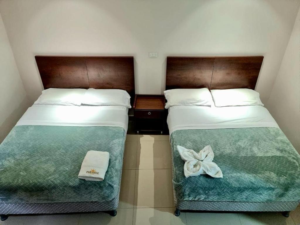 duas camas sentadas uma ao lado da outra num quarto em Paradise Resort em Los Santos
