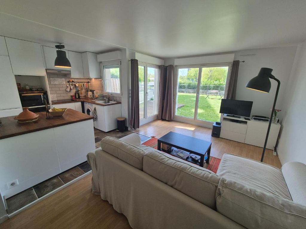 sala de estar con sofá y cocina en Vélodrome Montigny 2024, en Montigny-le-Bretonneux