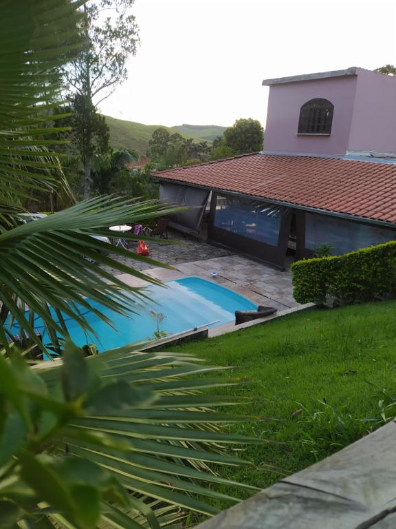 a swimming pool in the yard of a house at Casa de campo Domeni rustica e próximo a cidade de Juiz de Fora MG in Juiz de Fora