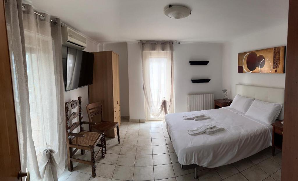 a bedroom with a white bed and a television at Appartamento in Villa Naomi in Rome
