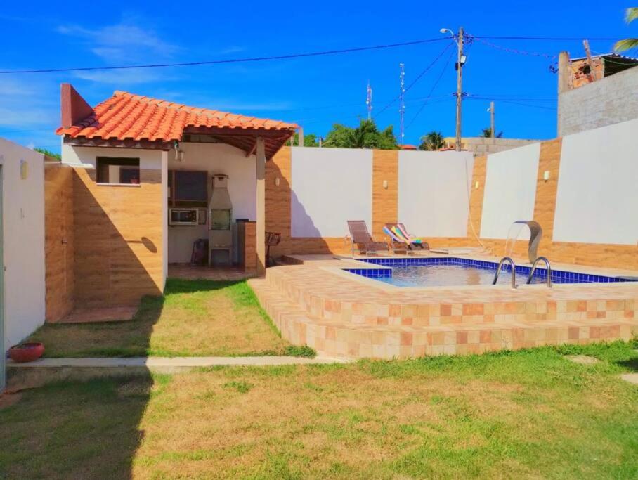 une maison avec une piscine dans la cour dans l'établissement Casa em Jauá, à Camaçari