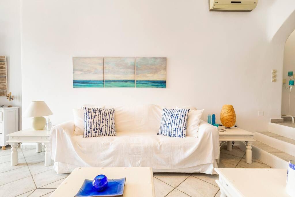 a living room with a white couch and a painting on the wall at Sea and Sun beach house at Platis Gialos in Platis Gialos