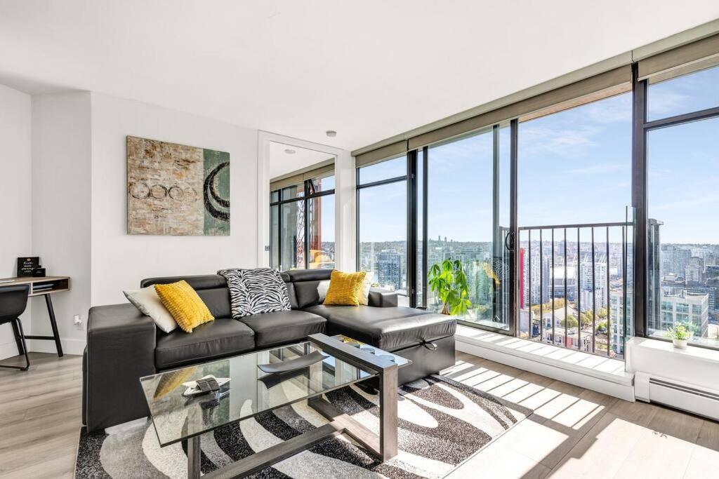 バンクーバーにあるCentral Luxury Apartment with Best City Views!のソファと大きな窓のあるリビングルーム