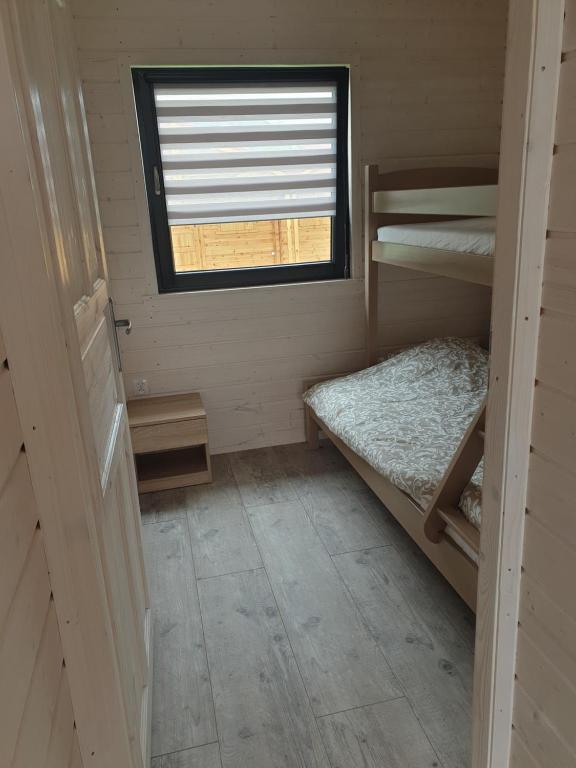a small room with two bunk beds and a window at Neptuno 5 Jantarowa in Chłopy