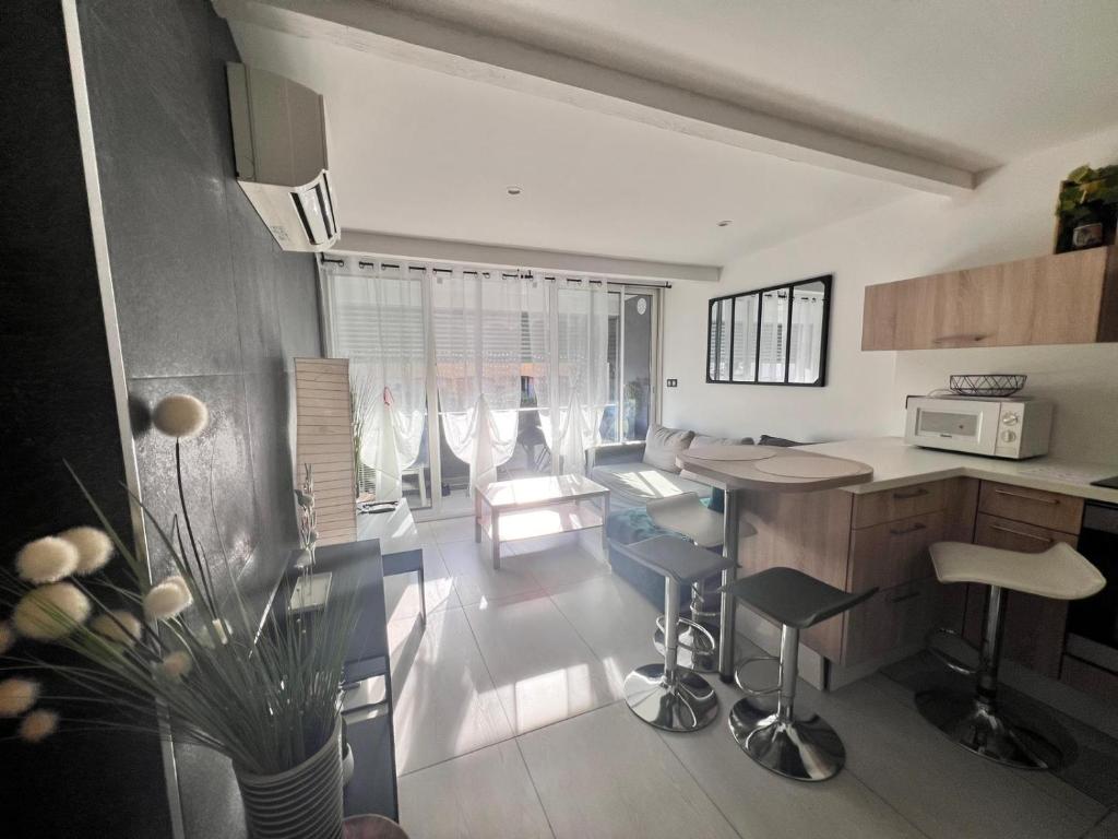 una cucina con un tavolo e sedie in una stanza di Bel appartement à 5 minutes de la plage a Cap d'Agde