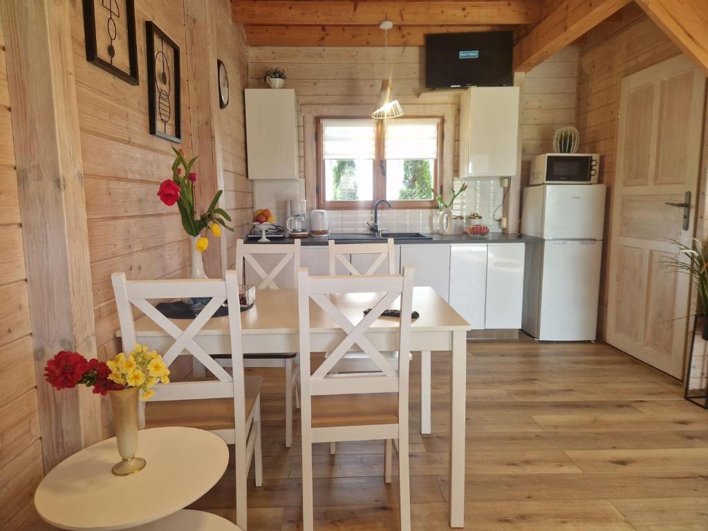 una cucina con tavolo e sedie in una cabina di Domki U Wojtka w Niechorzu a Niechorze
