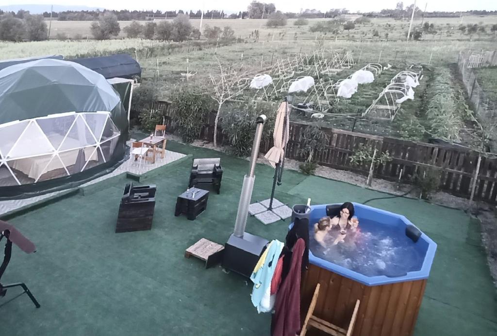 un gruppo di persone in una vasca idromassaggio in un cortile di Podere Kiri Dome Experience a Decimomannu