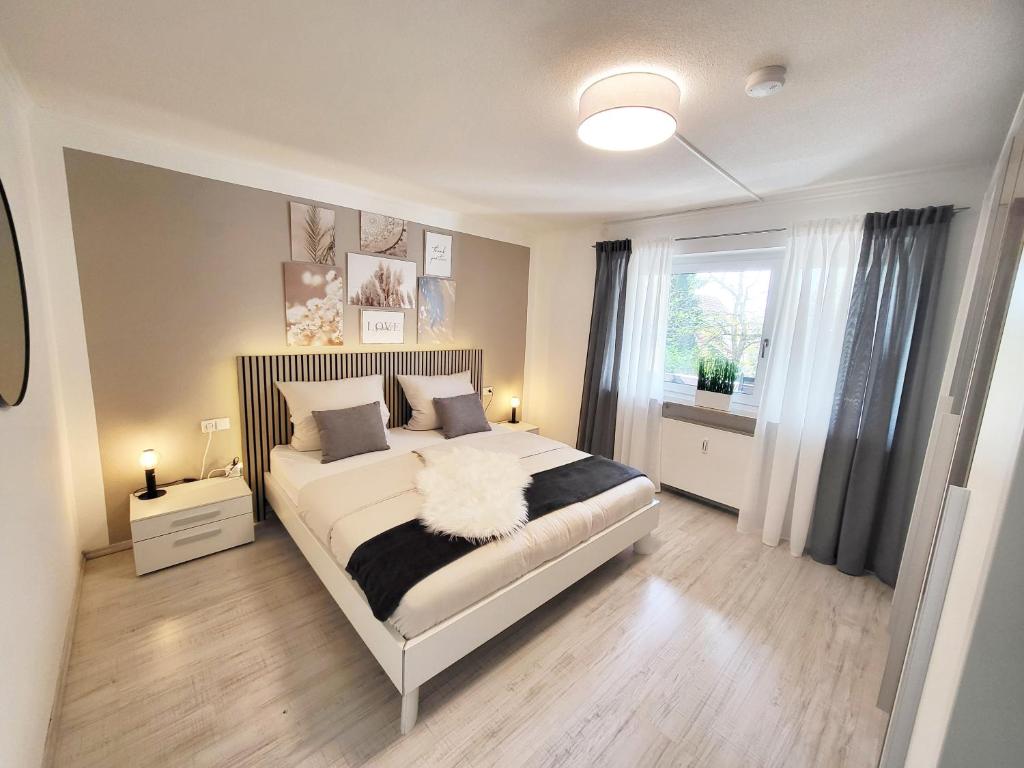 a bedroom with a large bed and a window at Moderne Ferienwohnung in Friedrichshafen