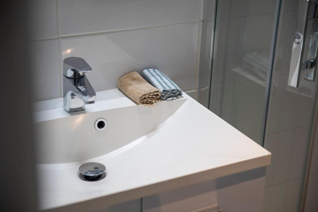 a bathroom with a white sink and a shower at Au Bout Du Quai in Granville