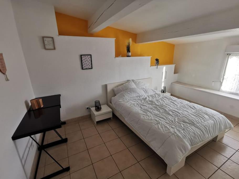 um quarto com uma cama e uma secretária. em Appartement avec terrasse Classé em Port-la-Nouvelle