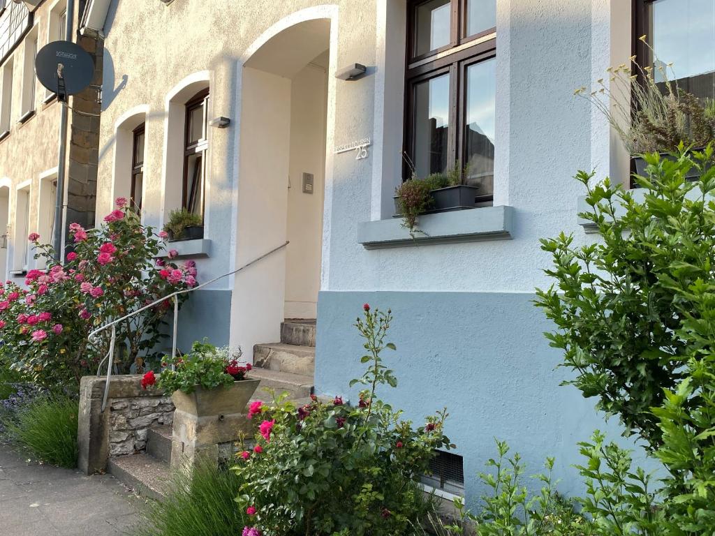 ein blaues Gebäude mit Blumen in den Fenstern in der Unterkunft Reisekultouren Apartments Detmold in Detmold