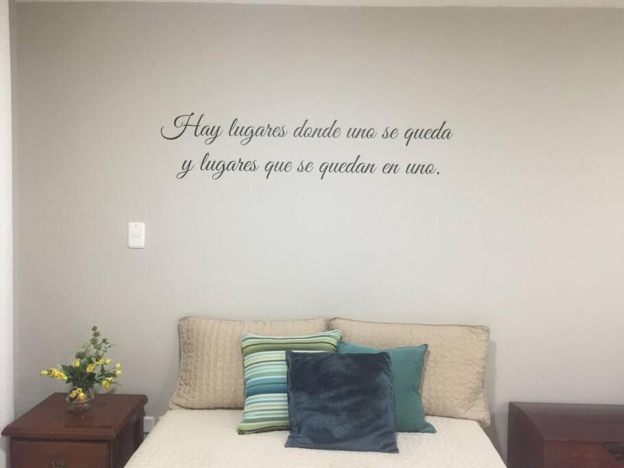 a bedroom with a bed with a quote on the wall at Ideal Apartaestudio con Piscina!!! in Dosquebradas