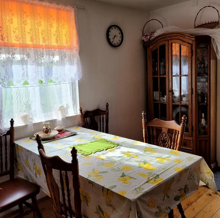 a dining room table with a yellow and white table cloth at Agroturystyka u Doroty in Rajgród