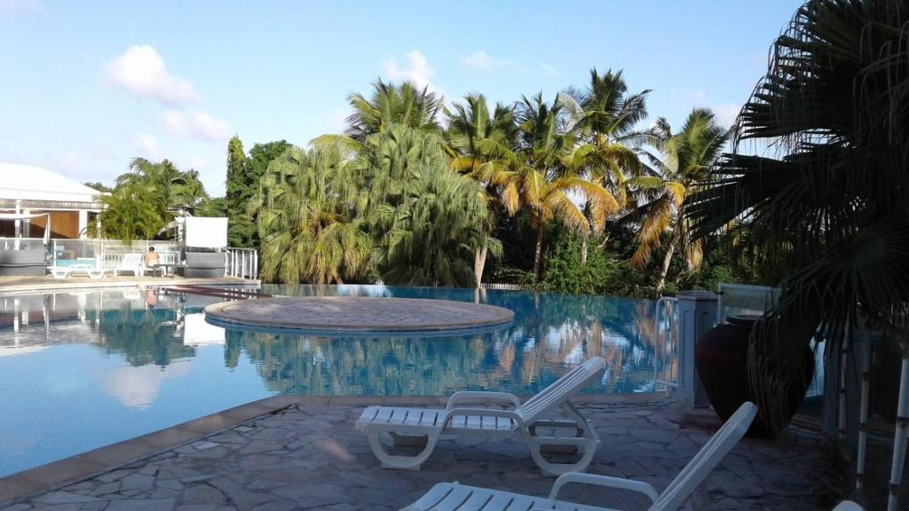 a swimming pool with two lounge chairs next to it at Joli Duplex à St Francois in Saint-François