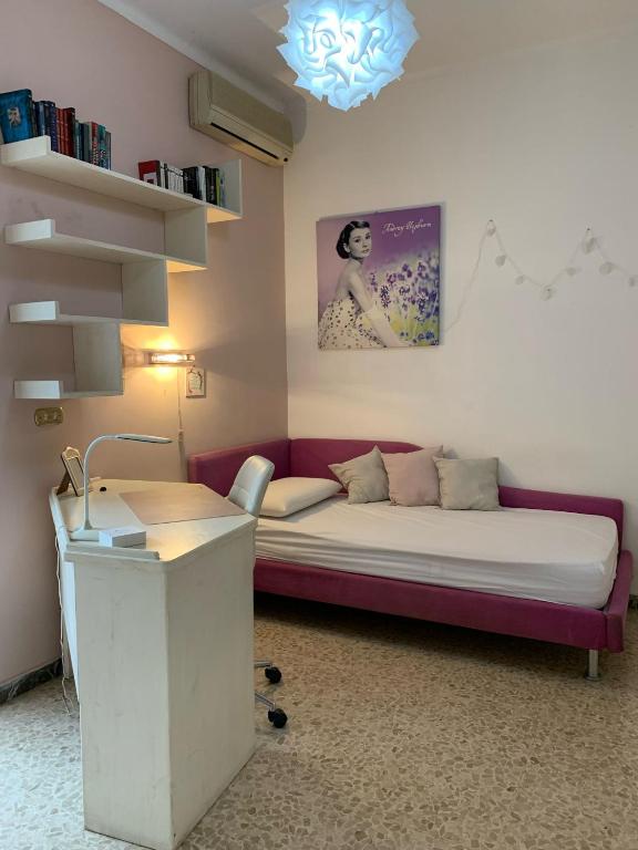una habitación con un sofá y un escritorio en GRAZIOSO MONOLOCALE OSTIA ROMA, en Lido di Ostia