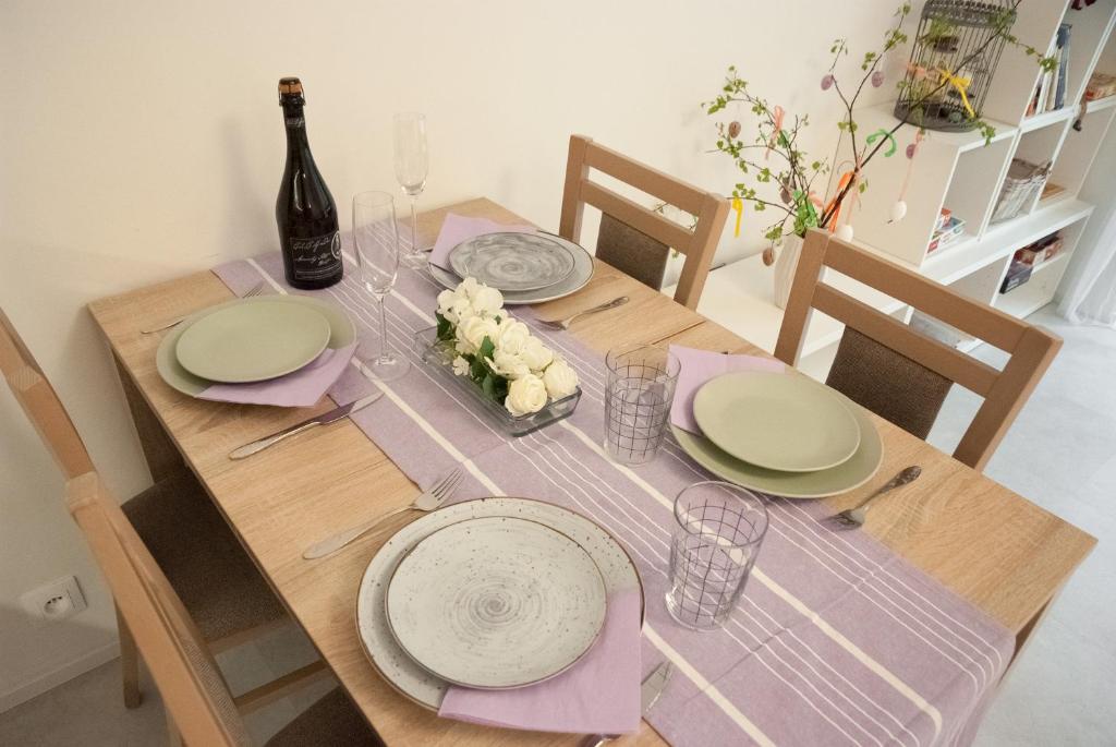 una mesa de madera con platos y una botella de vino en Apartmán víla Amálka, en Janov nad Nisou