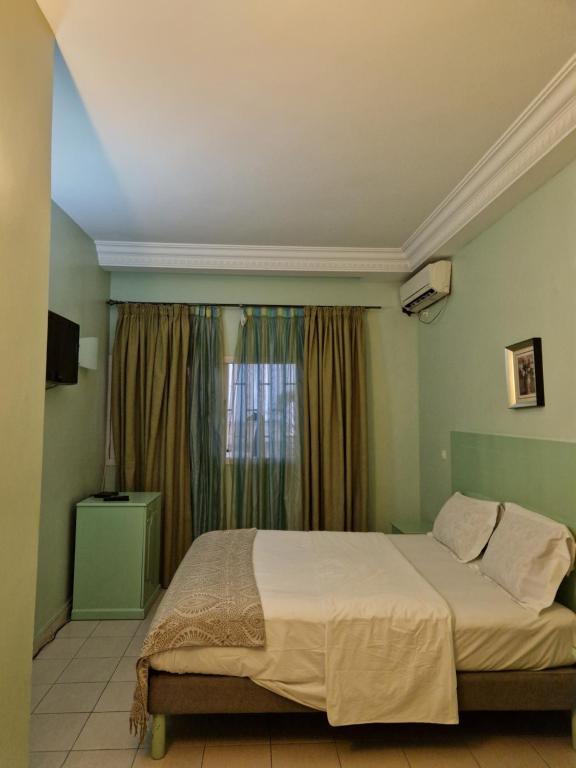 自由市的住宿－Association LES PYRAMIDES GABON，一间卧室设有一张大床和一个窗户。