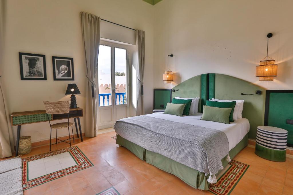 a bedroom with a large bed and a table at Le Palazzo in Essaouira