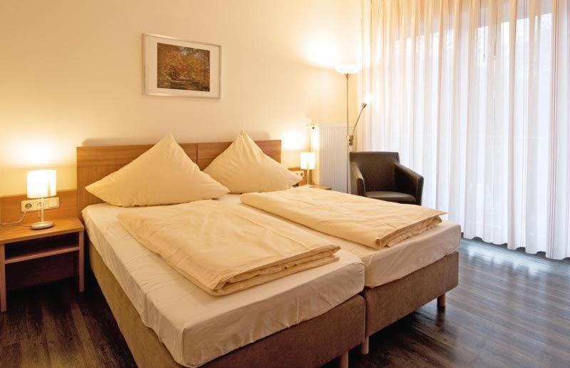 ein Schlafzimmer mit einem großen Bett und einem Stuhl in der Unterkunft Haller Hotel Garni in Monschau