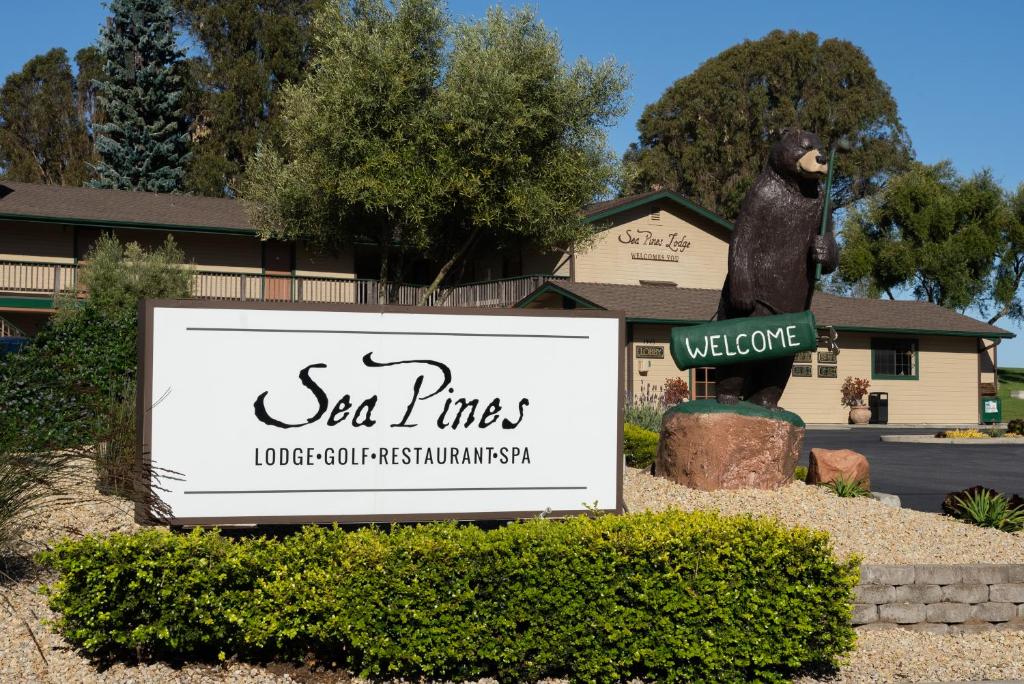 una señal frente a un edificio con una estatua de oso en Sea Pines Golf Resort, en Los Osos