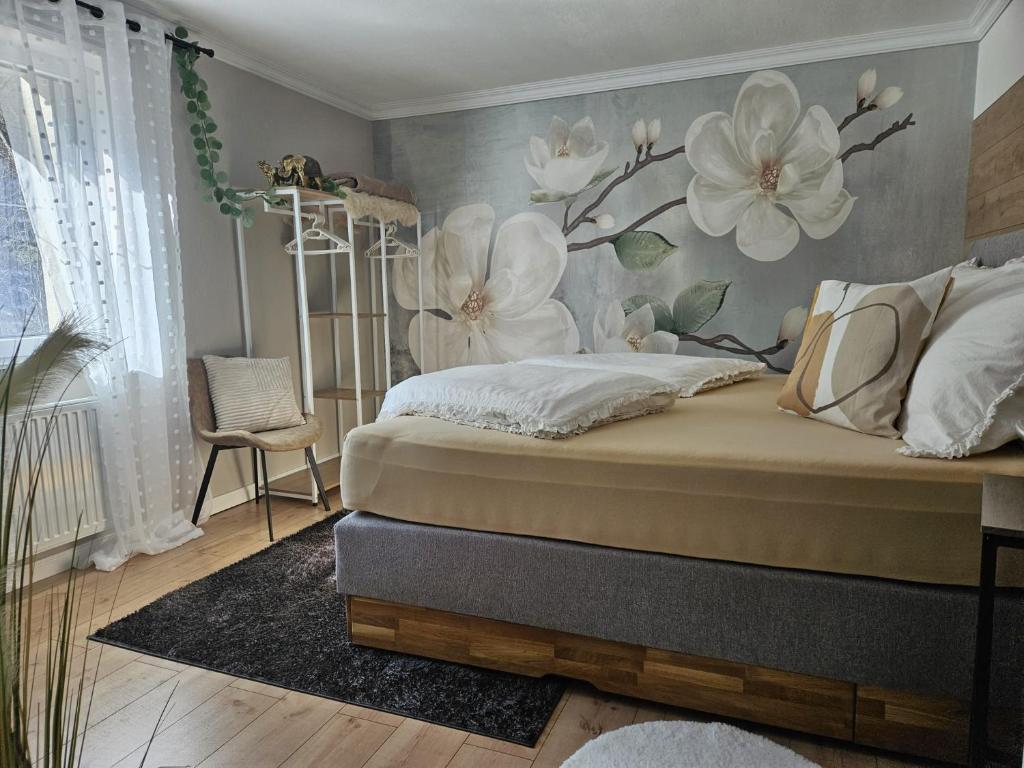 a bedroom with a bed with flowers on the wall at Ferienwohnung Ache in Oetz