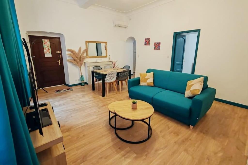 un salon avec un canapé bleu et une table dans l'établissement Appartement rénové centre historique de Bastia à deux pas du Vieux Port, à Bastia