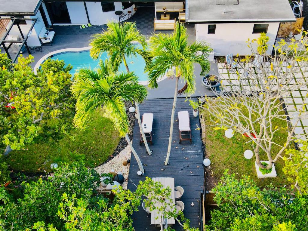 een uitzicht op een achtertuin met palmbomen en een zwembad bij Entire Villa, North Miami Beach with pool on canal! in Miami