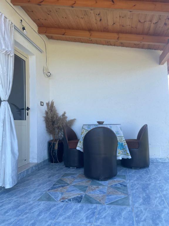 a table and chairs in a room with a door at Diarla's Home 1 in Fier