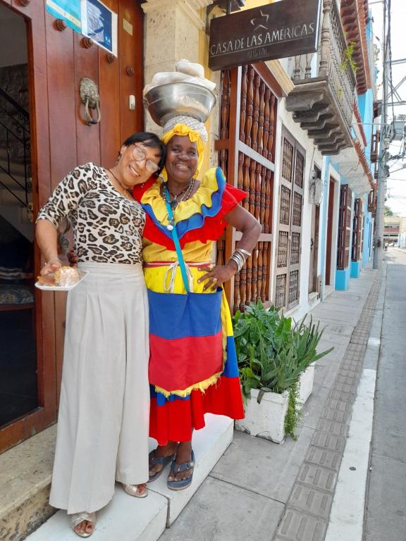 twee vrouwen die naast elkaar staan op straat bij Hostal Casa de las Americas in Cartagena
