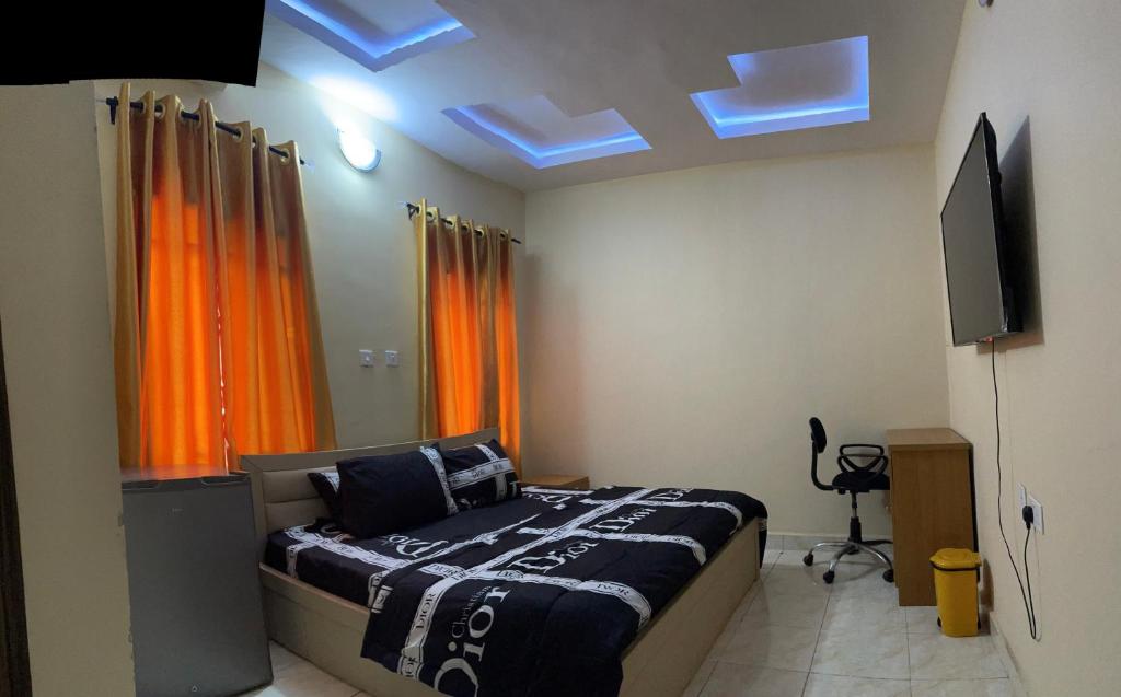 a bedroom with a bed and a flat screen tv at CasaCasa Apartments in Enugu