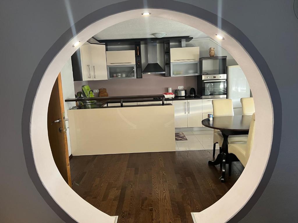 a kitchen with a table and a mirror at Apartman Iris in Vogošća