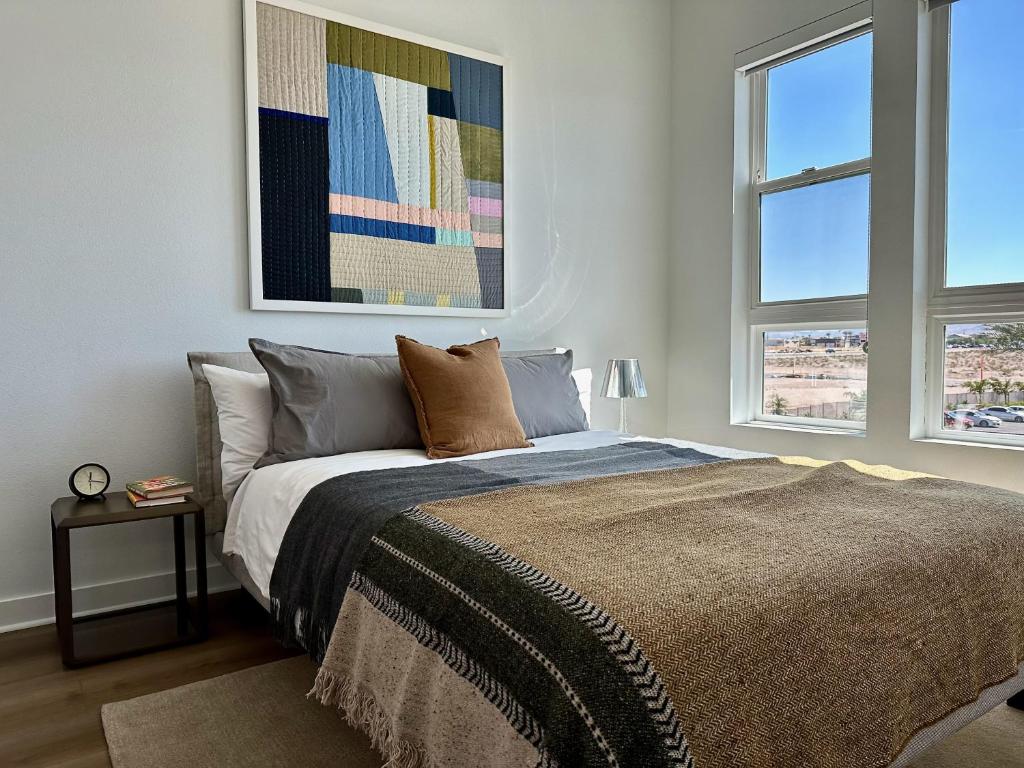 a bedroom with a bed and two windows at 1 Bedroom Luxury Ariva Apartment in Las Vegas