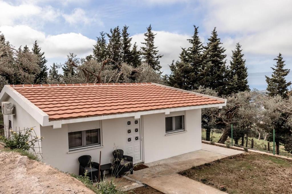 uma pequena casa branca com um telhado vermelho em Olive Grove em Bar