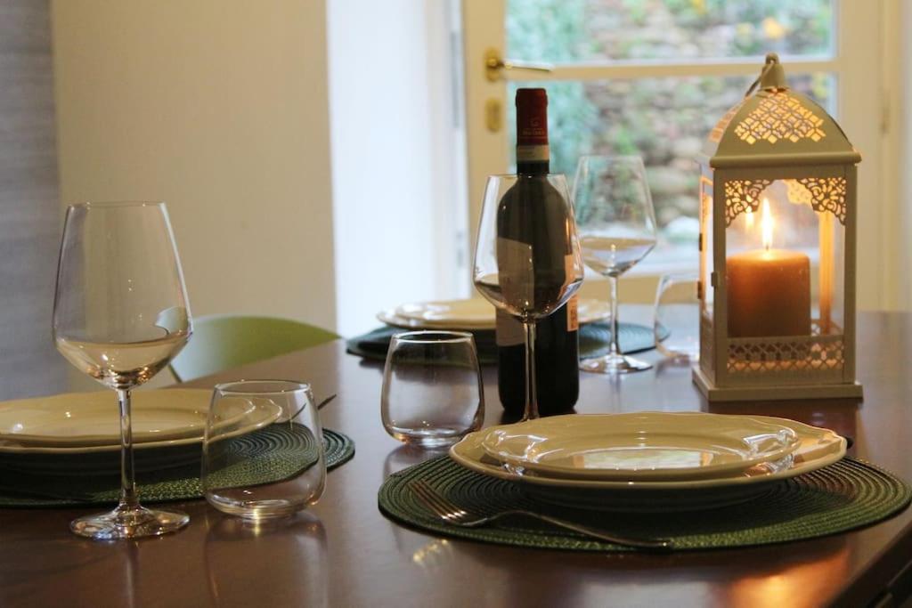a table with glasses and a bottle of wine and a candle at Borgo dei vigneti in Montecarlo