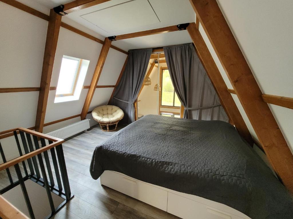 ein Schlafzimmer mit einem Bett und einem Treppenaufgang in der Unterkunft Casuta Floare de Fan in Trăisteni