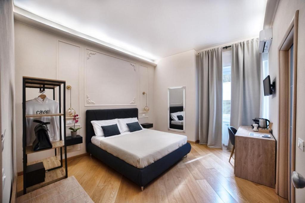 Habitación pequeña con cama y espejo en Sea Pearl Luxury Rooms, en La Spezia